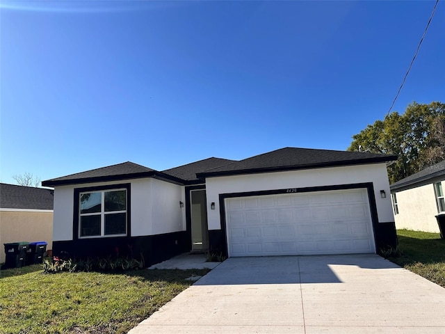 view of front facade with stucco siding, an attached garage, concrete driveway, and a front lawn