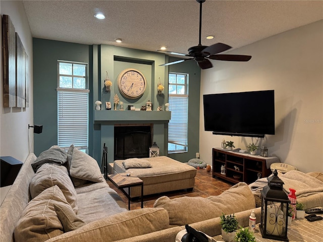 living area with recessed lighting, a large fireplace, a textured ceiling, and ceiling fan