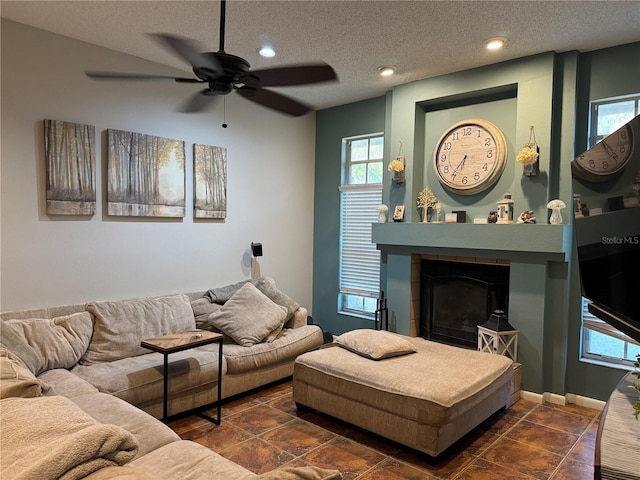 living area featuring recessed lighting, a textured ceiling, ceiling fan, and a fireplace