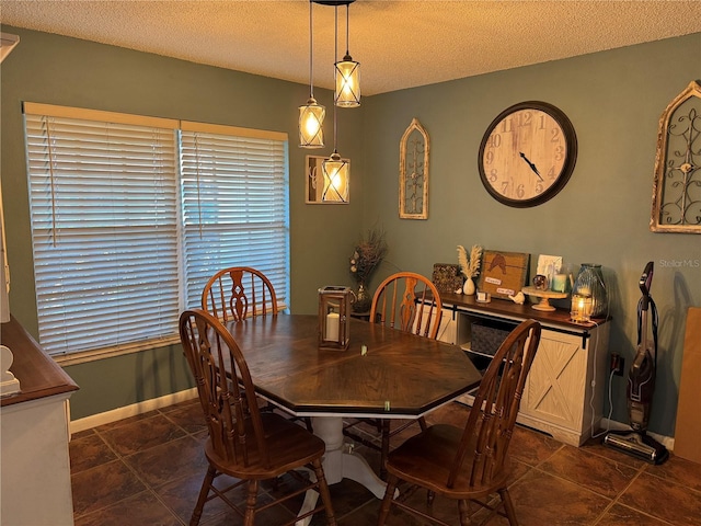 dining space with a textured ceiling and baseboards