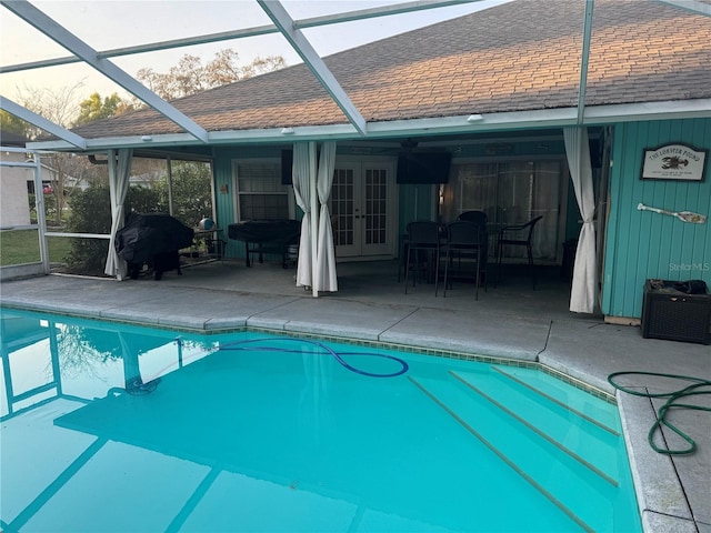 outdoor pool featuring a patio area, grilling area, french doors, and a lanai