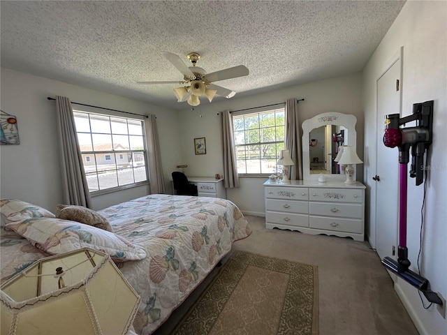 bedroom with a textured ceiling, a ceiling fan, and light colored carpet