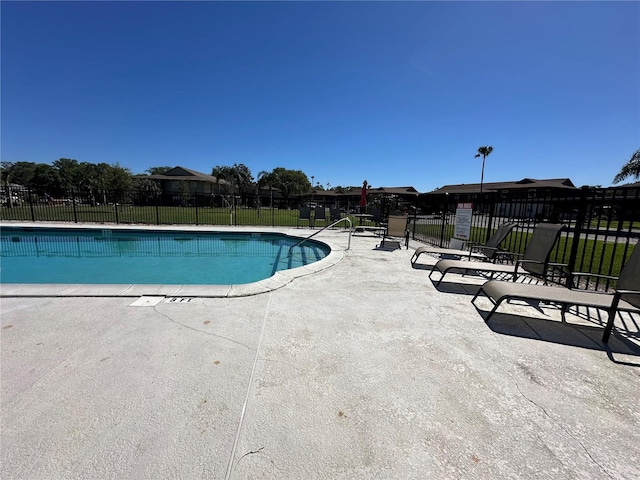 community pool featuring fence and a patio