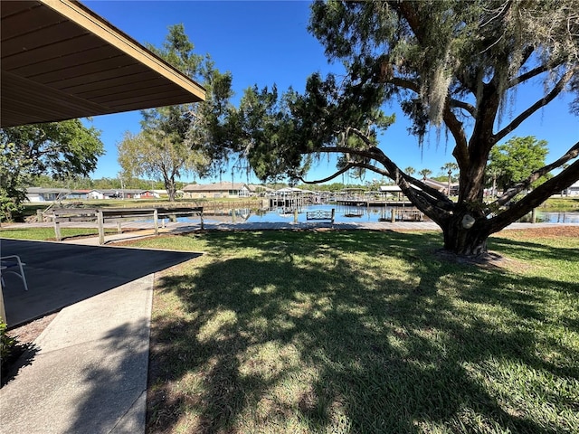 view of yard featuring a water view and a dock