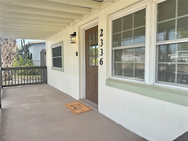 view of exterior entry featuring covered porch