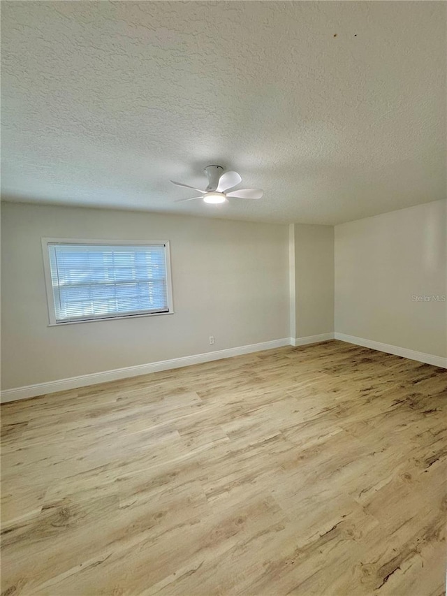 unfurnished room featuring light wood-style flooring, a textured ceiling, baseboards, and ceiling fan