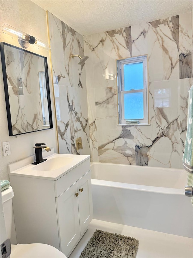 bathroom with a textured ceiling, toilet, vanity, and shower / washtub combination