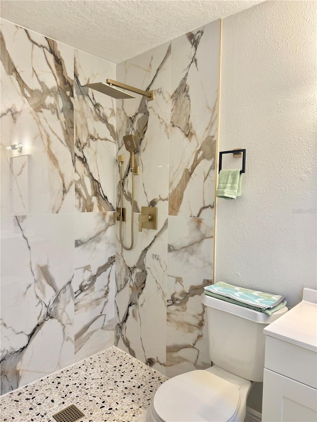 bathroom with vanity, a marble finish shower, toilet, a textured wall, and a textured ceiling
