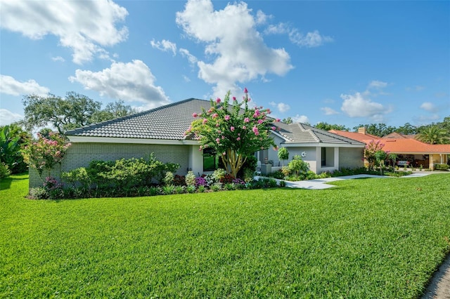 365 N Spaulding Cv, Lake Mary, FL 32746 - view of front facade featuring a tiled roof, a front lawn, and brick siding
