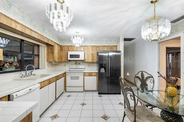 34 Misty Meadow Ln, Mulberry, FL 33860 - kitchen featuring a notable chandelier, white appliances, a textured ceiling, tile countertops, and a sink