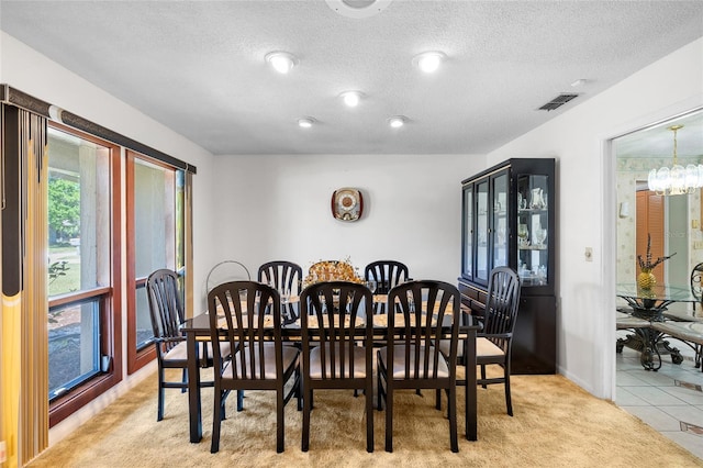 34 Misty Meadow Ln, Mulberry, FL 33860 - dining room featuring a textured ceiling, an inviting chandelier, light colored carpet, and visible vents