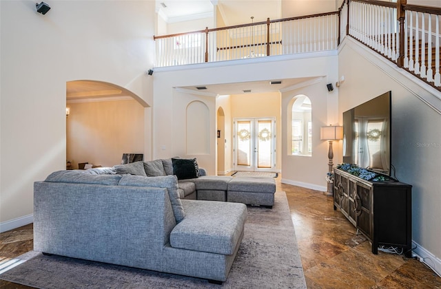 3033 Stonegate Falls Dr, Land O Lakes, FL 34638 - living area featuring arched walkways, baseboards, ornamental molding, and a towering ceiling