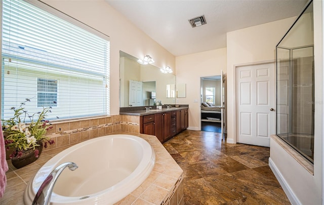 3033 Stonegate Falls Dr, Land O Lakes, FL 34638 - ensuite bathroom featuring a relaxing tiled tub, a shower with door, visible vents, ensuite bath, and vanity