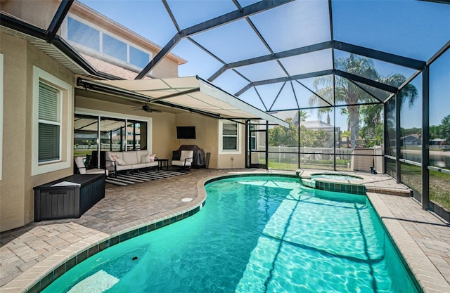 3033 Stonegate Falls Dr, Land O Lakes, FL 34638 - view of swimming pool featuring ceiling fan, a pool with connected hot tub, an outdoor hangout area, a patio area, and glass enclosure