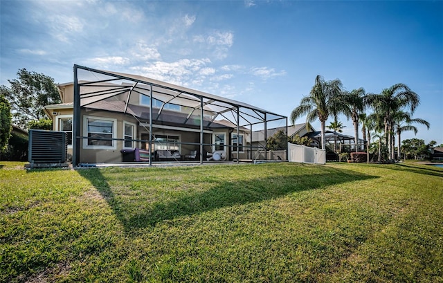 3033 Stonegate Falls Dr, Land O Lakes, FL 34638 - rear view of property with a lawn, glass enclosure, and stucco siding