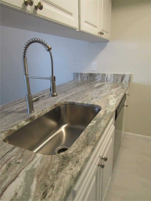 3102 W Horatio St Unit 12, Tampa, FL 33609 - kitchen view of a sink, baseboards, white cabinetry, and light stone countertops