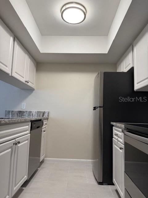 3102 W Horatio St Unit 12, Tampa, FL 33609 - kitchen with stainless steel dishwasher, a raised ceiling, white cabinets, and range
