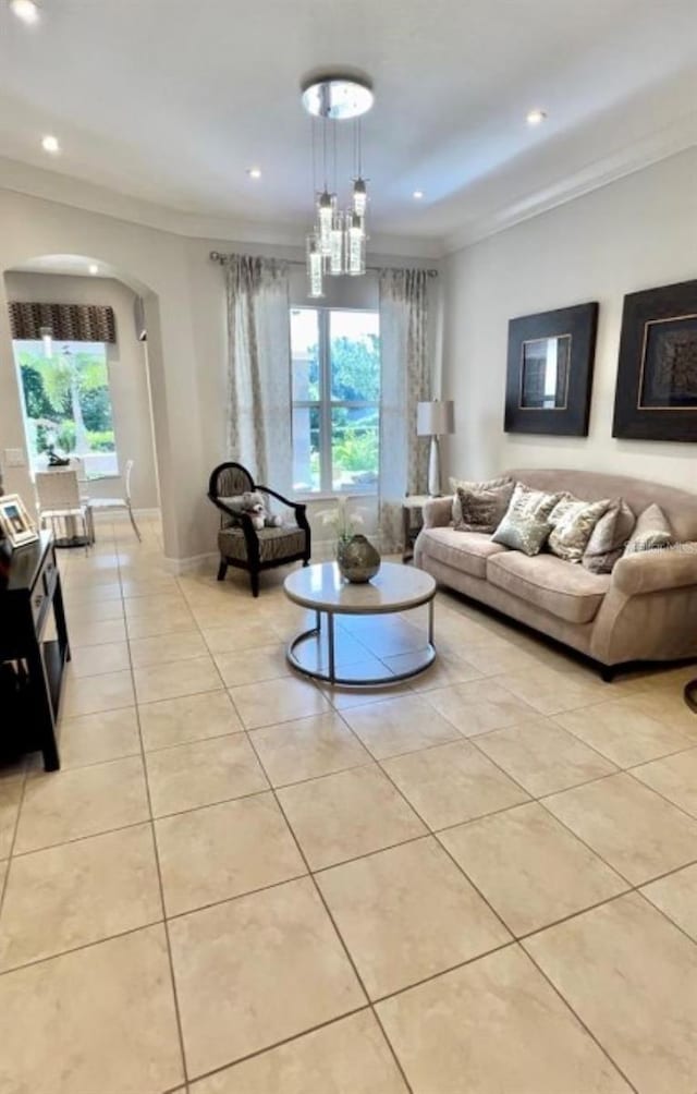 living room with arched walkways, light tile patterned flooring, crown molding, and recessed lighting