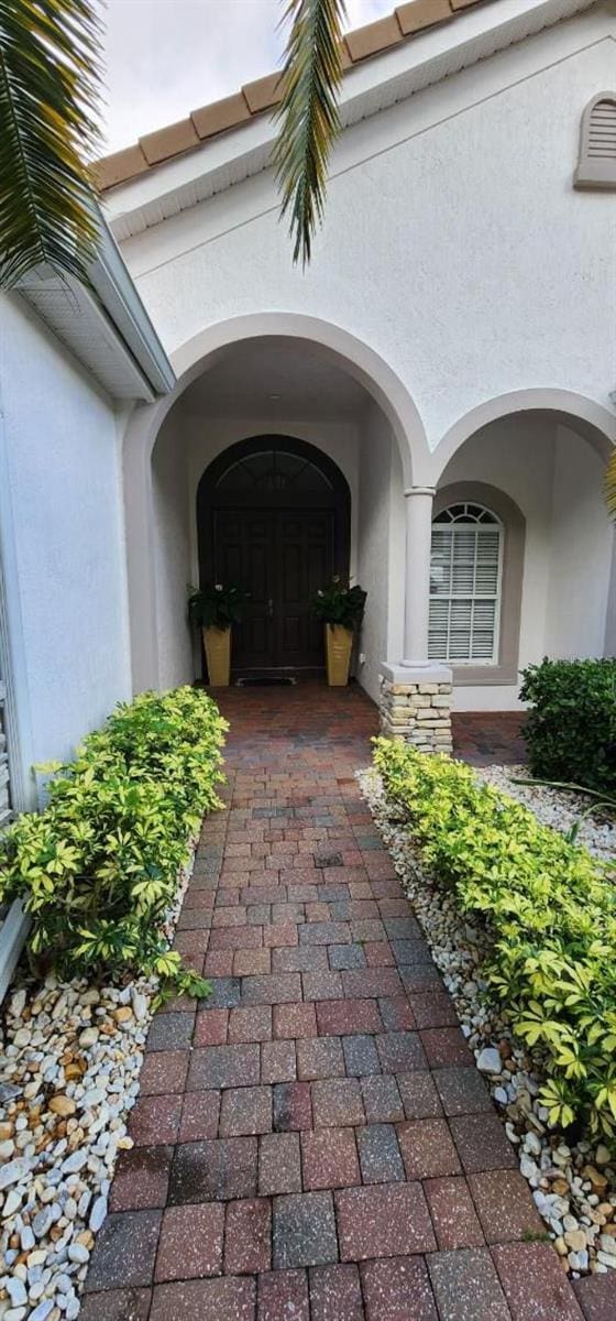 view of exterior entry featuring stucco siding