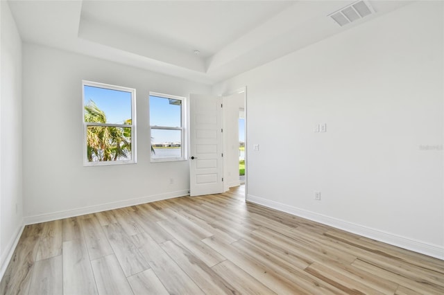 17245 Savory Mist Cir, Bradenton, FL 34211 - spare room with baseboards, visible vents, a raised ceiling, and light wood-style floors