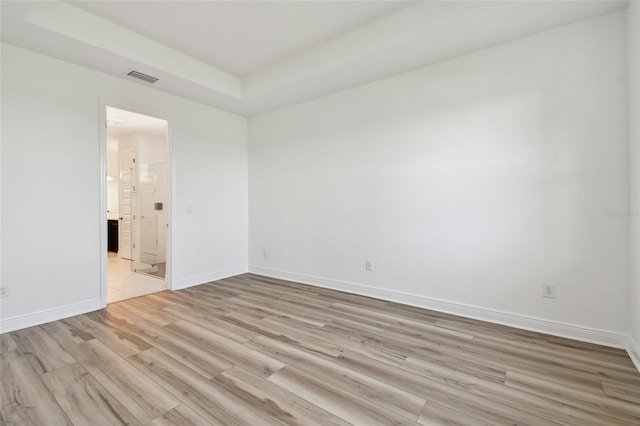17245 Savory Mist Cir, Bradenton, FL 34211 - empty room featuring visible vents, a raised ceiling, light wood finished floors, and baseboards