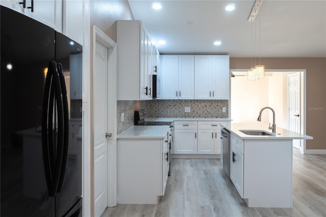 3426 Somerset Ave, Deltona, FL 32738 - kitchen with an island with sink, backsplash, a sink, light wood-style flooring, and appliances with stainless steel finishes