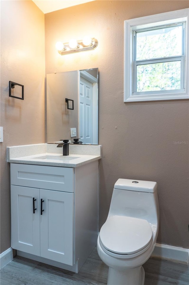 3426 Somerset Ave, Deltona, FL 32738 - bathroom with wood finished floors, vanity, toilet, and baseboards