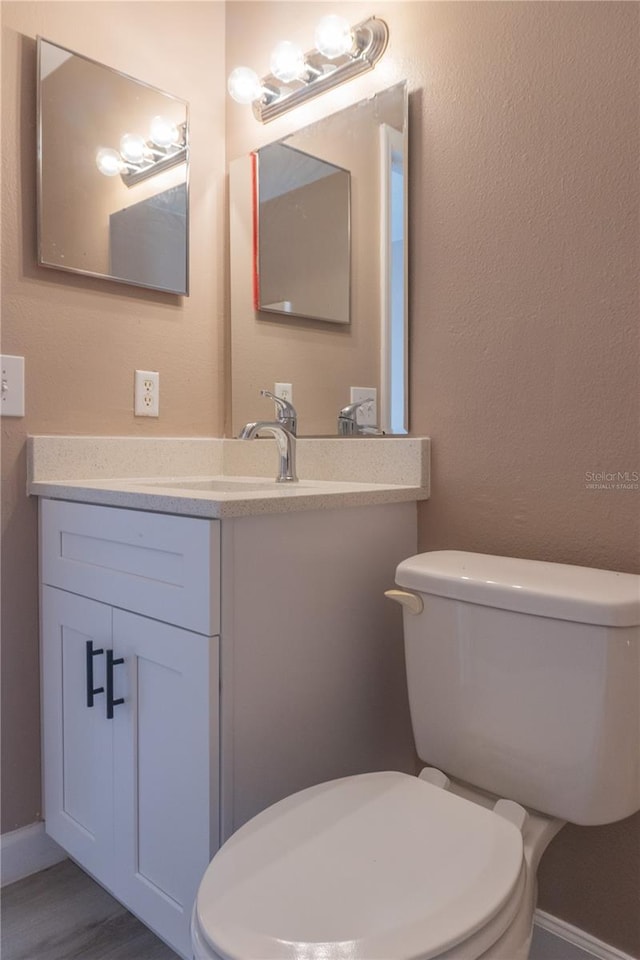 3426 Somerset Ave, Deltona, FL 32738 - half bathroom with wood finished floors, toilet, and vanity