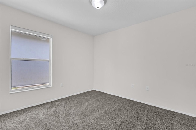 unfurnished room with carpet floors and baseboards