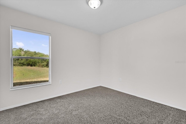 carpeted spare room featuring baseboards
