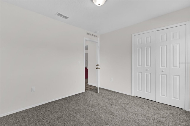 unfurnished bedroom featuring baseboards, carpet, a closet, and visible vents
