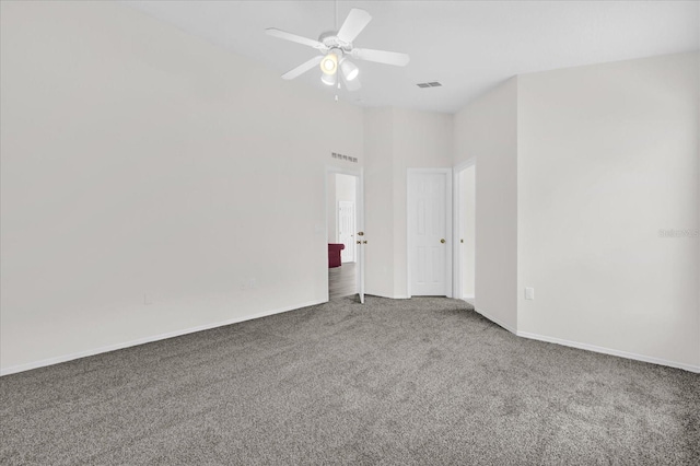 unfurnished room with visible vents, carpet flooring, baseboards, and a ceiling fan