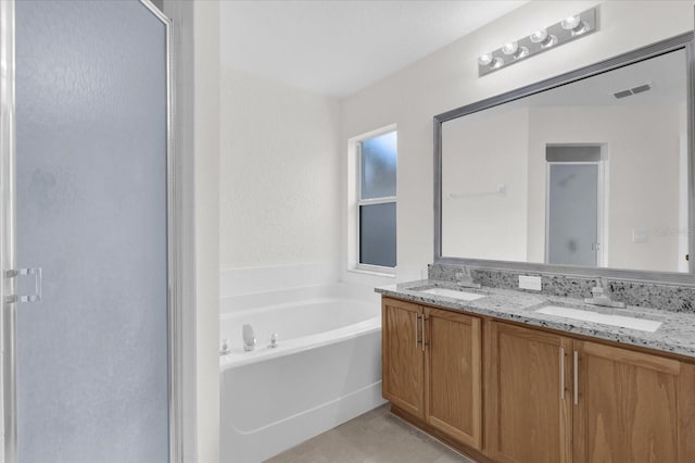 full bathroom with visible vents, a sink, a garden tub, and a stall shower