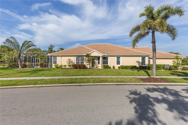 view of front of home featuring stucco siding, a front lawn, and a tile roof
