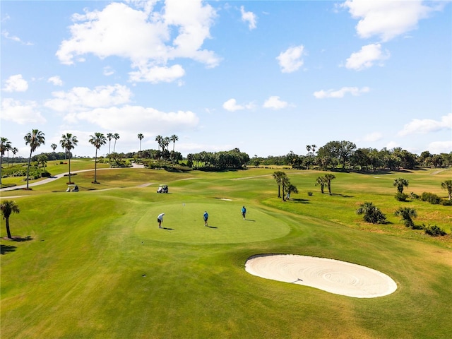 view of home's community with a lawn and view of golf course
