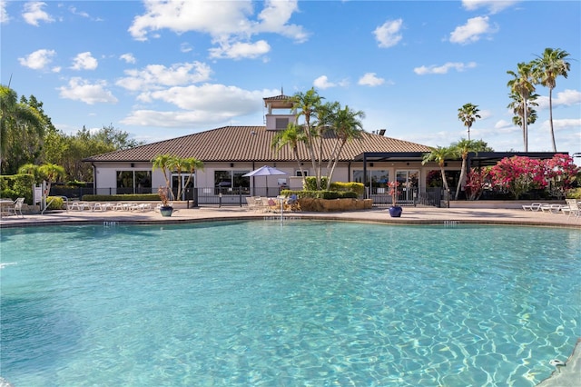 community pool with fence and a patio area