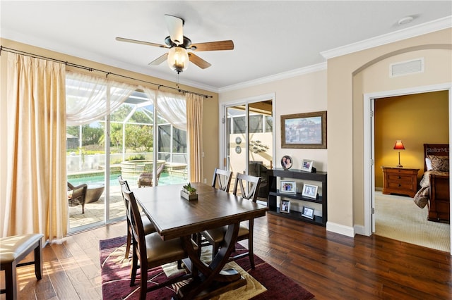 dining room featuring ceiling fan, dark wood finished floors, baseboards, visible vents, and ornamental molding
