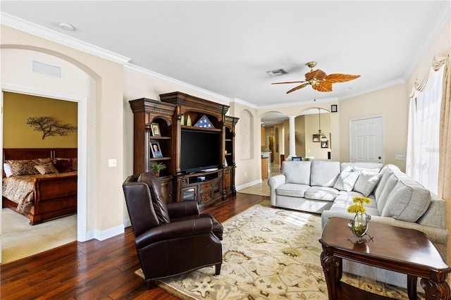 living room with arched walkways, visible vents, ornamental molding, and dark wood finished floors