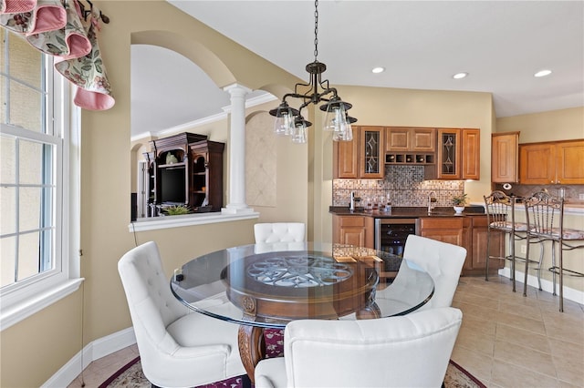 dining space with recessed lighting, decorative columns, wine cooler, and light tile patterned floors