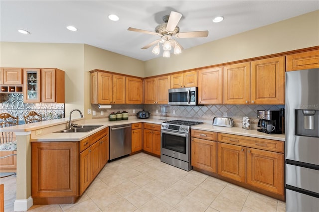 kitchen with a sink, tasteful backsplash, stainless steel appliances, and a peninsula