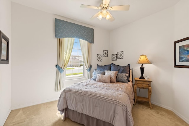 bedroom featuring baseboards, ceiling fan, and light colored carpet