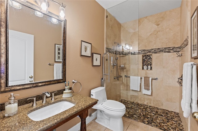 bathroom featuring tile patterned floors, vanity, toilet, and tiled shower