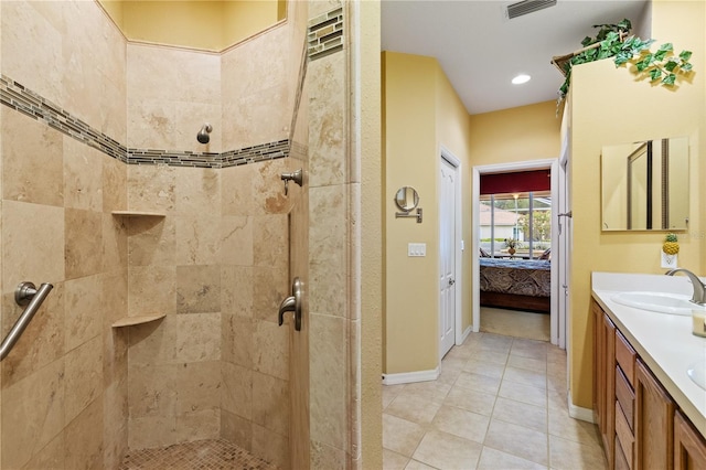 ensuite bathroom featuring visible vents, vanity, ensuite bathroom, baseboards, and a tile shower