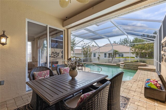exterior space with ceiling fan, a pool with connected hot tub, glass enclosure, a patio, and outdoor dining space