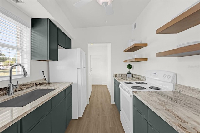 kitchen featuring open shelves, a sink, green cabinets, light wood-style floors, and white appliances