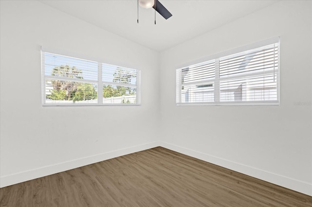 empty room with baseboards, ceiling fan, and wood finished floors