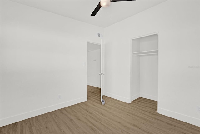 unfurnished bedroom featuring baseboards, wood finished floors, and a closet