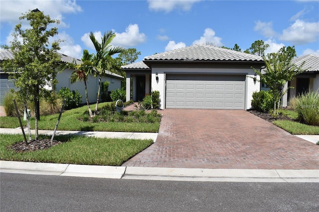 2735 Lavandula Ct, North Port, FL 34289 - view of front of house featuring a garage, decorative driveway, stucco siding, and a tiled roof