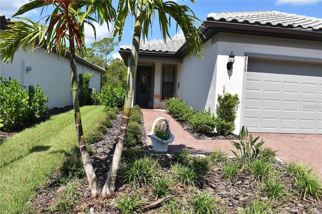 2735 Lavandula Ct, North Port, FL 34289 - view of front of house with decorative driveway, a garage, a tile roof, and stucco siding