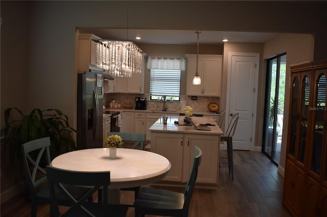 2735 Lavandula Ct, North Port, FL 34289 - kitchen featuring tasteful backsplash, black fridge with ice dispenser, light countertops, white cabinets, and dark wood-style floors